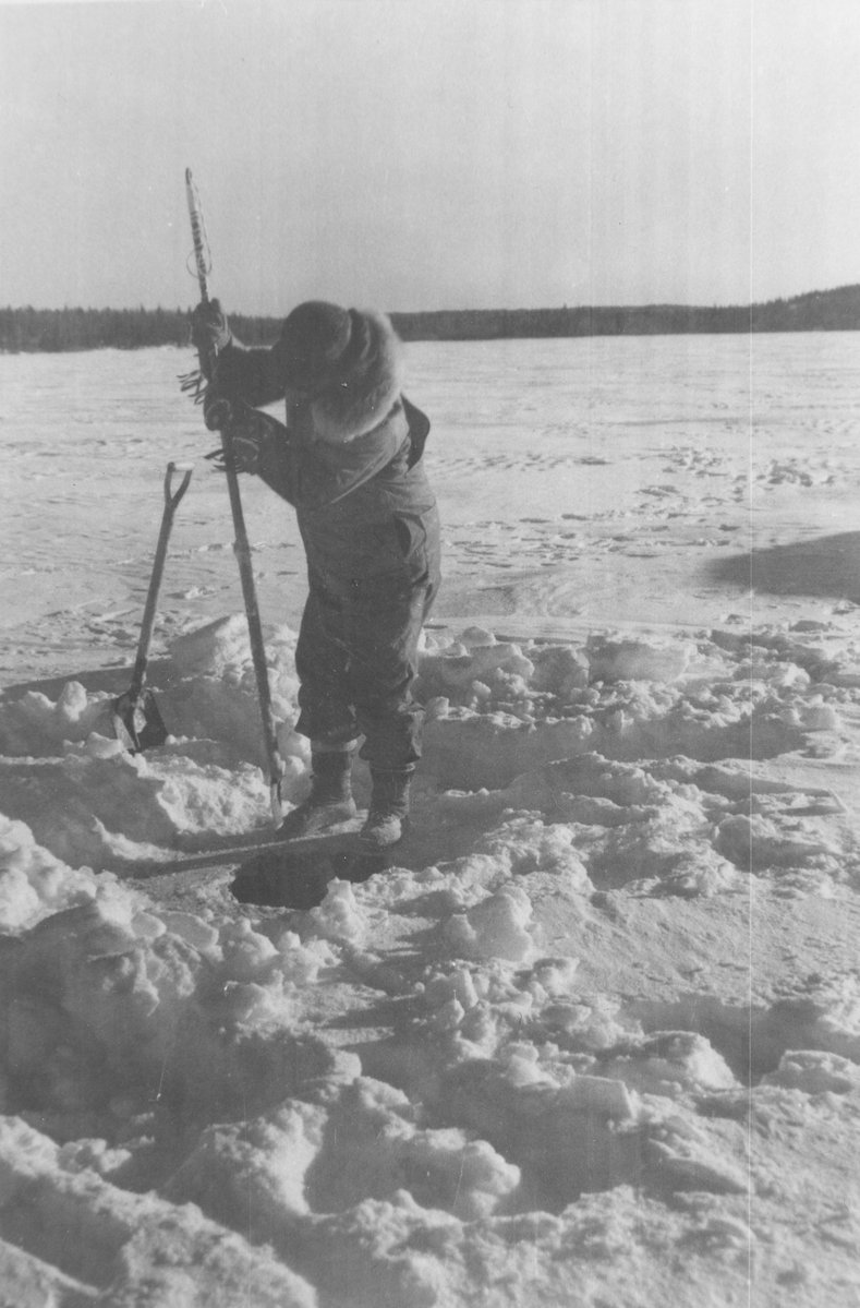 Commercial Fisherman Cutting Hole in Ice, Institute for Northern Studies fonds