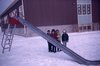 Children by a slide in the Black Lake School. yard. 12/69, R.M.  Bone  fonds