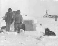 B.W. Currie and unidentified Inuk man outside igloo.